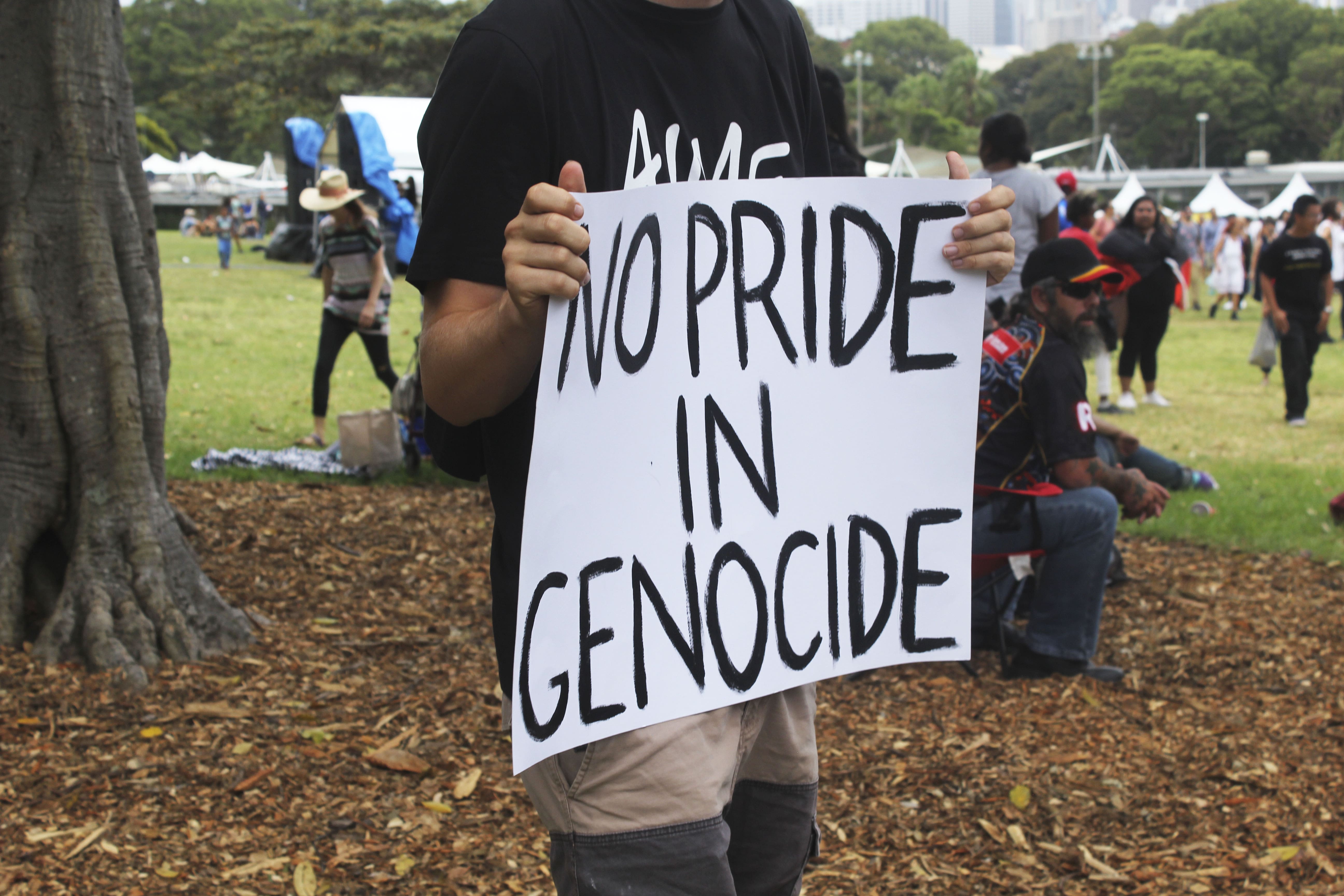 Protester holds sign reading 'no pride in genocide'.