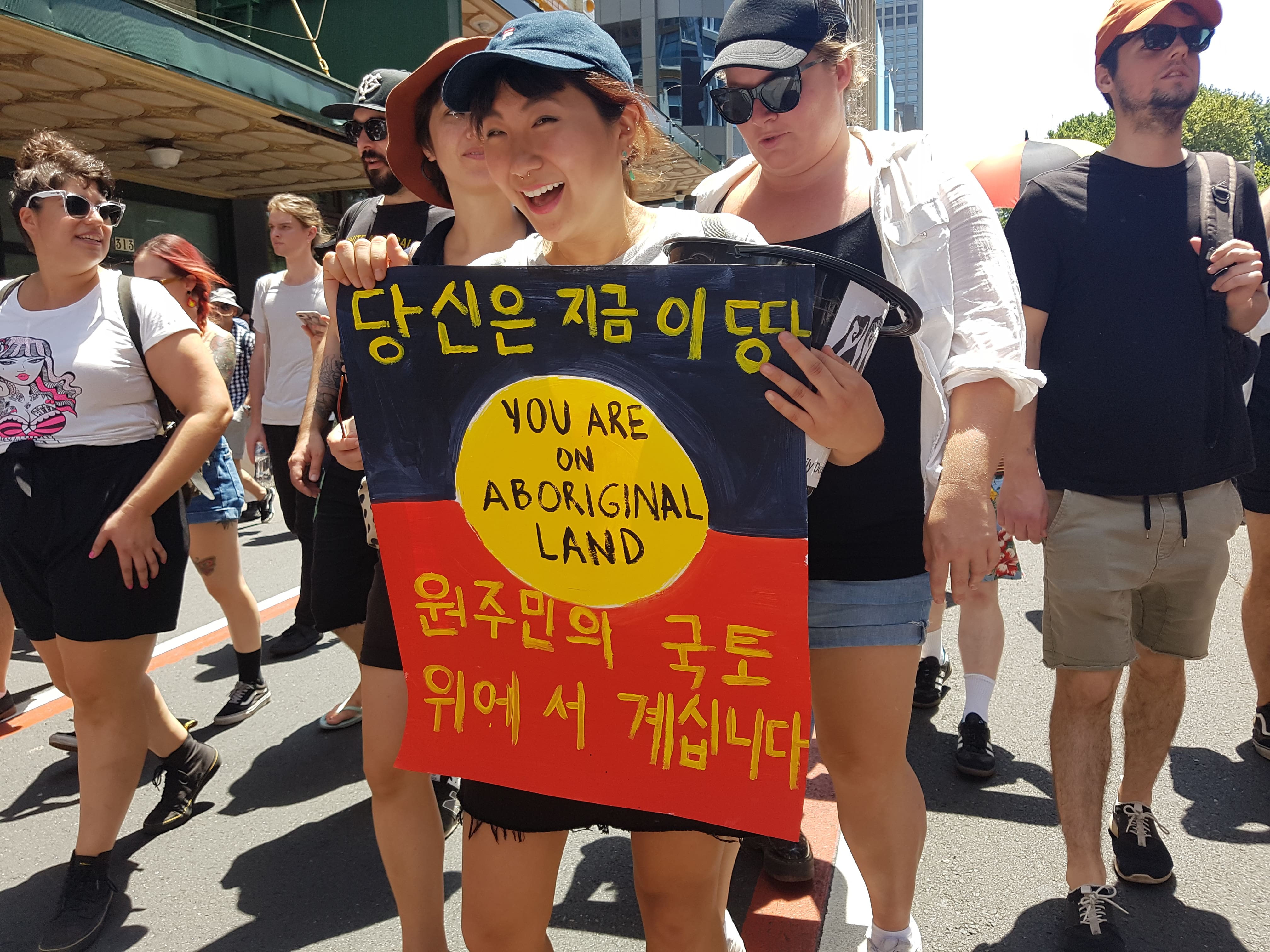 The rally proceeds southwards along Elizabeth Street. Previous Honi Soit reporter Soo-Min Shim holds a bilingual Korean and English sign, which reads “You are on Aboriginal land.” 
