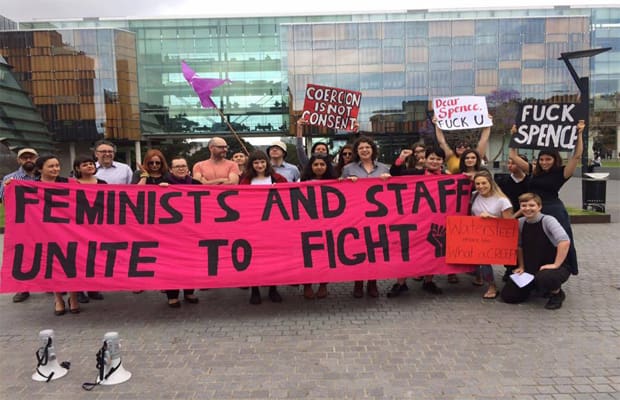 An image of a protest organised by the Women's Collective. Protestors bear a sign that reads "feminists and staff unite to fight"