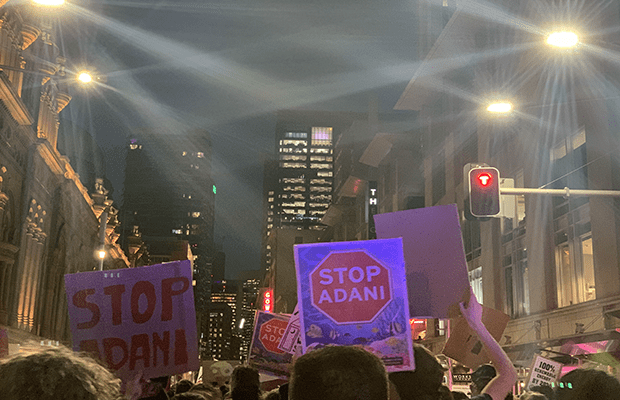 Photo from the climate strike along George Street, picturing signs that read STOP ADANI.