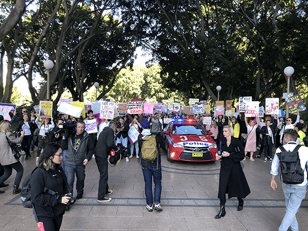 Photograph: the front of the march walking through Hyde Park, people holding pro-choice posters, and among the crowd is a police car. In front of the crowd are other journalists photographing the march.